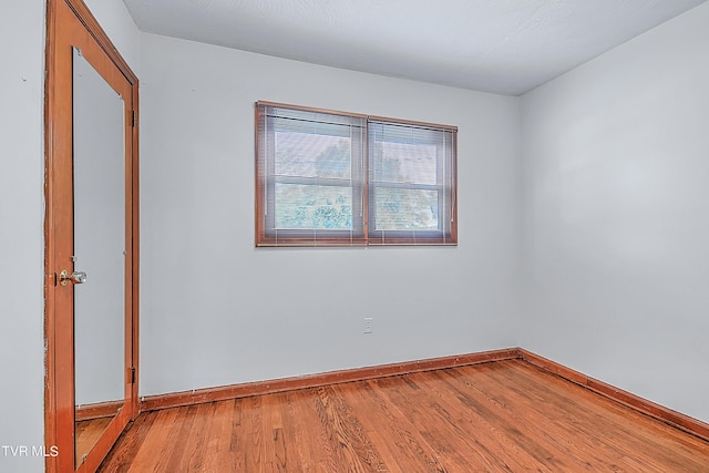 spare room featuring wood finished floors and baseboards