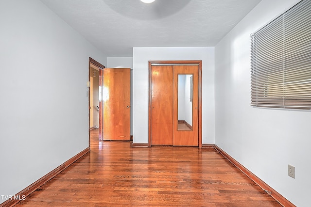 unfurnished bedroom featuring baseboards and wood finished floors