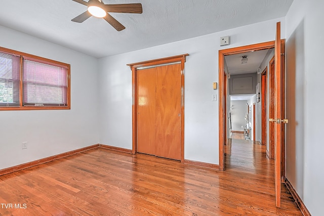 unfurnished bedroom with ceiling fan, baseboards, and wood finished floors