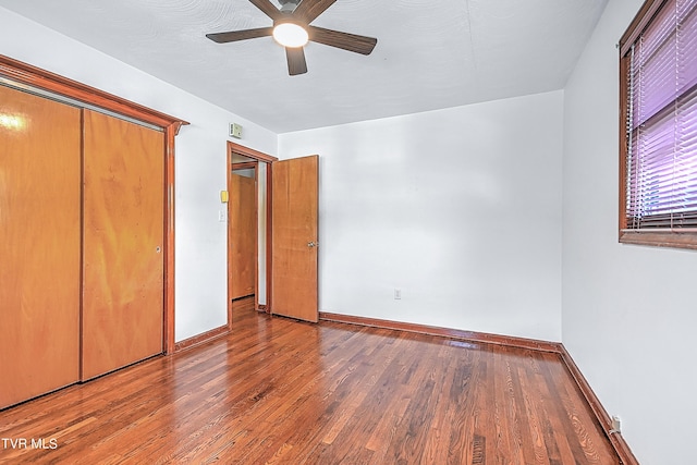 unfurnished bedroom featuring baseboards, wood finished floors, and ceiling fan
