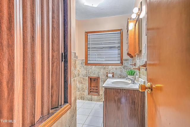bathroom with vanity, tile patterned flooring, a wainscoted wall, and tile walls