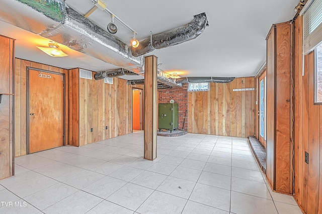 below grade area featuring wooden walls, visible vents, and light tile patterned flooring