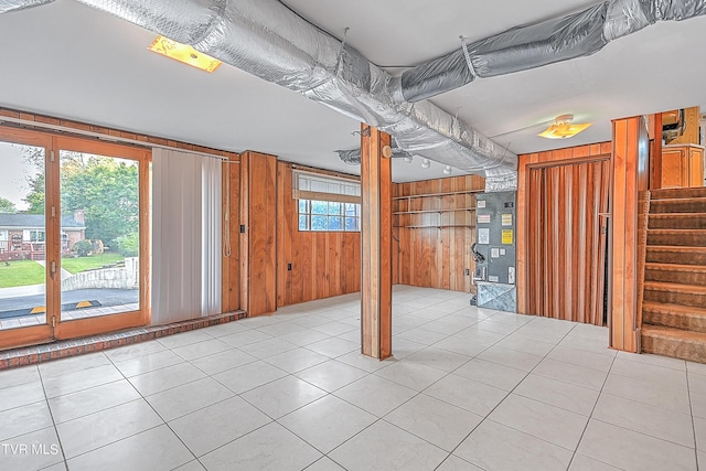 basement featuring wooden walls, stairway, and tile patterned flooring