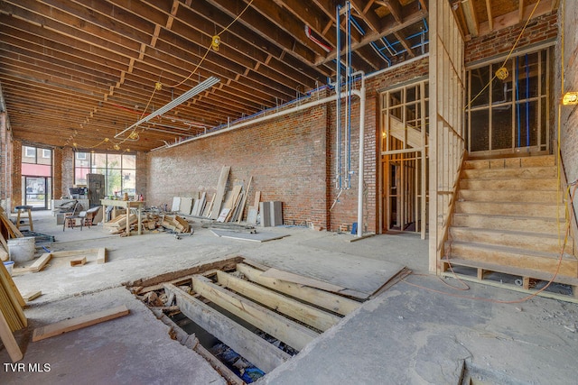 misc room featuring brick wall and stairs