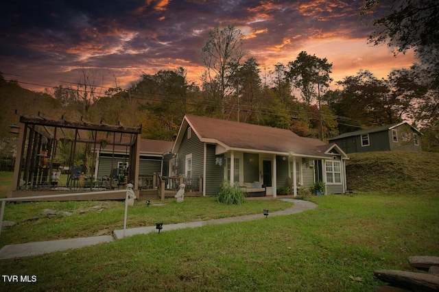 view of front facade with covered porch and a lawn