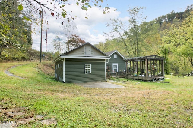 back of property with a wooden deck, a yard, and a patio area