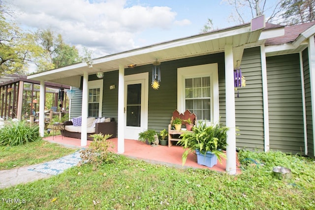 view of exterior entry with a yard and an outdoor hangout area