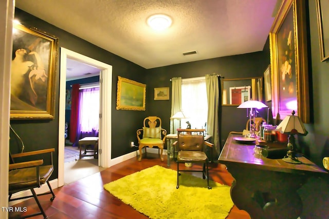 sitting room featuring a textured ceiling, wood-type flooring, and a healthy amount of sunlight