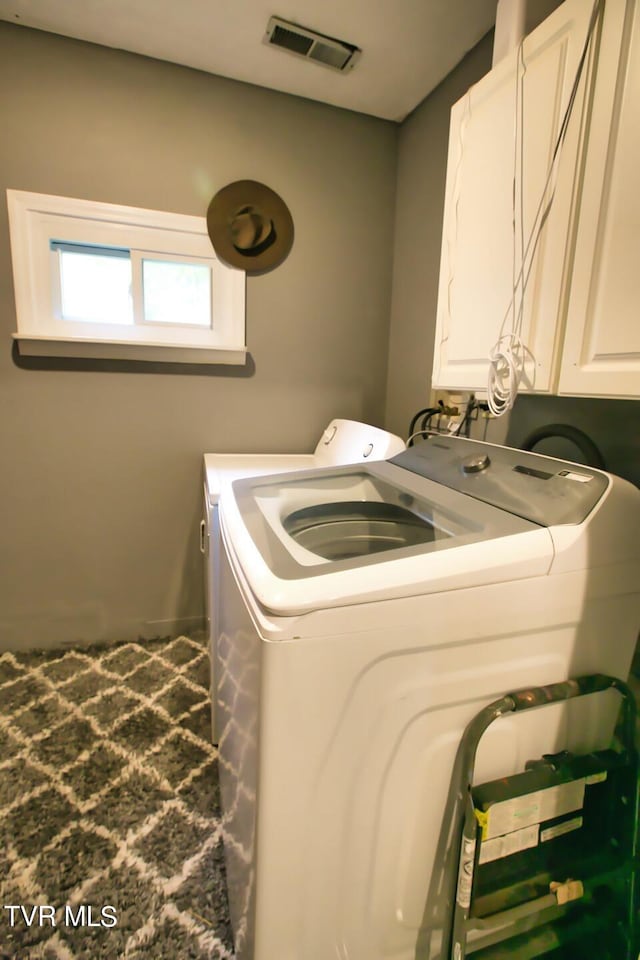 laundry room featuring washing machine and dryer and cabinets