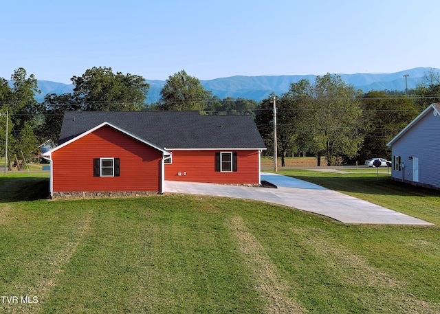 view of property exterior featuring a yard and a mountain view