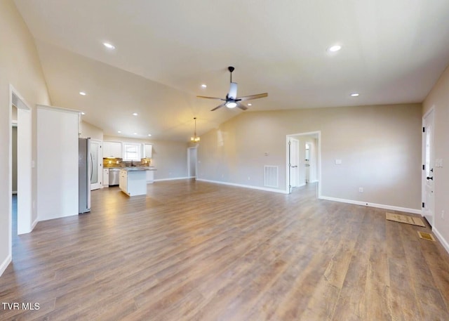 unfurnished living room featuring lofted ceiling, light wood-type flooring, and ceiling fan