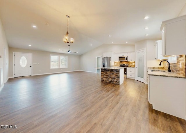 kitchen with light hardwood / wood-style flooring, sink, a center island, white cabinets, and appliances with stainless steel finishes