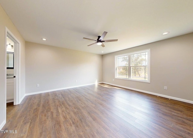 unfurnished room with ceiling fan and dark hardwood / wood-style flooring