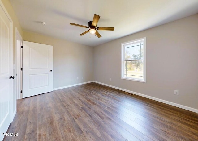 unfurnished room with dark wood-type flooring and ceiling fan