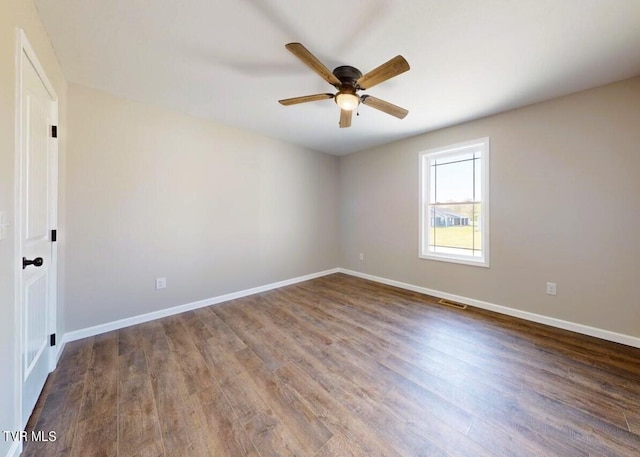 spare room with ceiling fan and dark hardwood / wood-style flooring