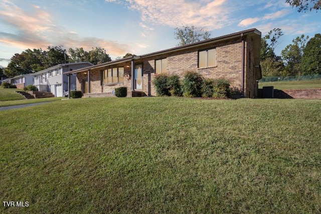 ranch-style home featuring a front lawn and brick siding