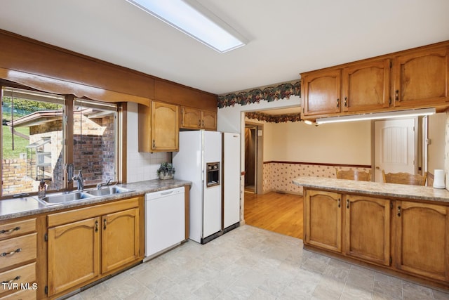 kitchen featuring backsplash, sink, and white appliances