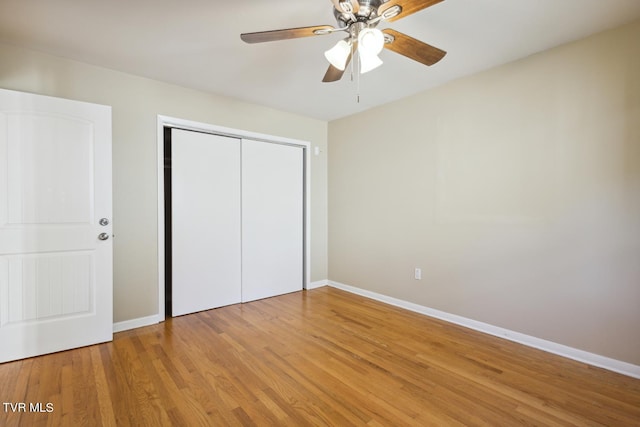 unfurnished bedroom featuring a closet, hardwood / wood-style floors, and ceiling fan