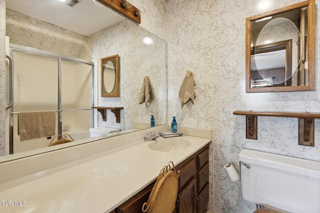 bathroom featuring vanity, toilet, and walk in shower