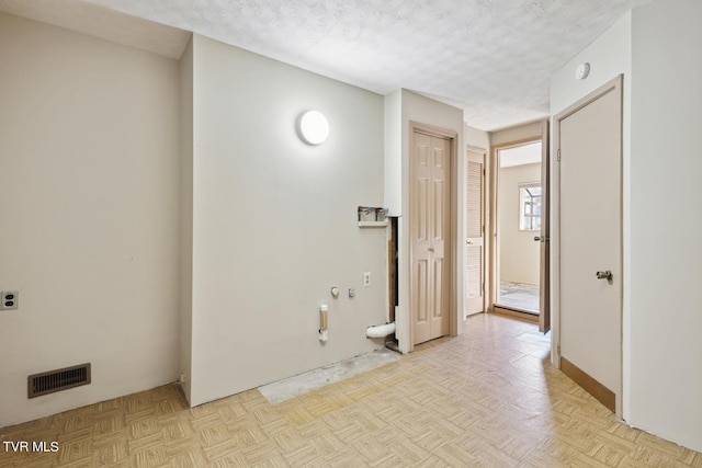 interior space featuring a textured ceiling and light parquet floors