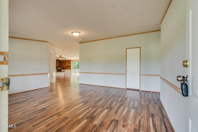 unfurnished room featuring crown molding, dark hardwood / wood-style flooring, and a textured ceiling