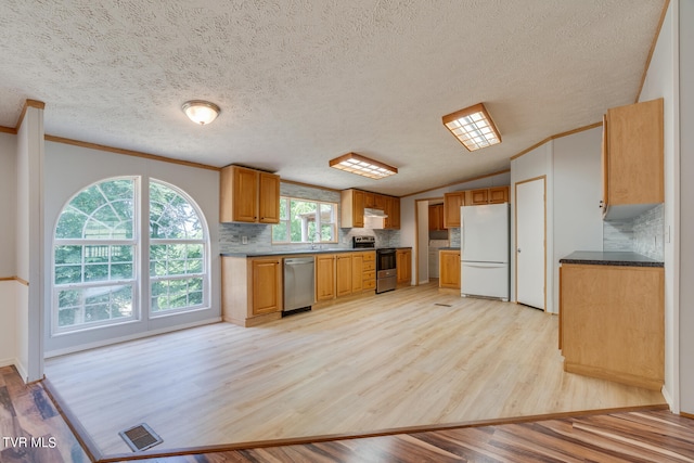 kitchen with tasteful backsplash, a textured ceiling, stainless steel appliances, crown molding, and light hardwood / wood-style flooring