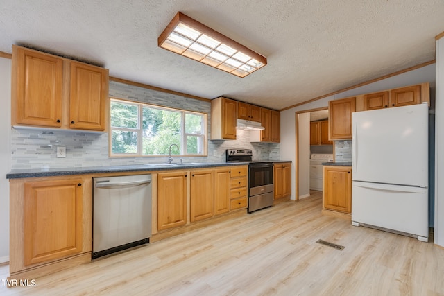 kitchen featuring crown molding, light wood-type flooring, stainless steel appliances, and vaulted ceiling