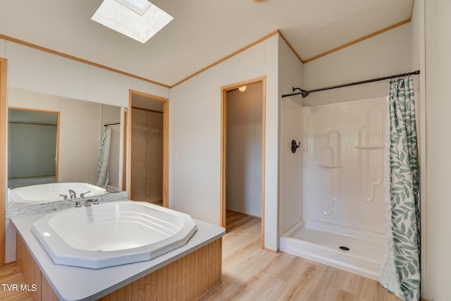 bathroom with crown molding, curtained shower, vaulted ceiling with skylight, and hardwood / wood-style floors