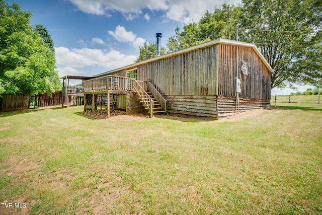 rear view of property featuring a yard and a wooden deck