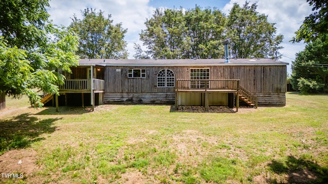 rear view of property with a wooden deck and a yard