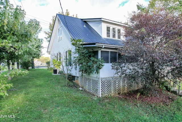 view of property exterior featuring a yard and a sunroom