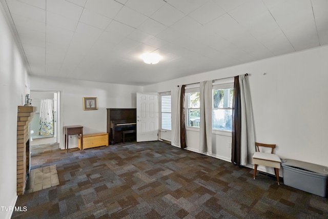 unfurnished living room with dark colored carpet and a fireplace