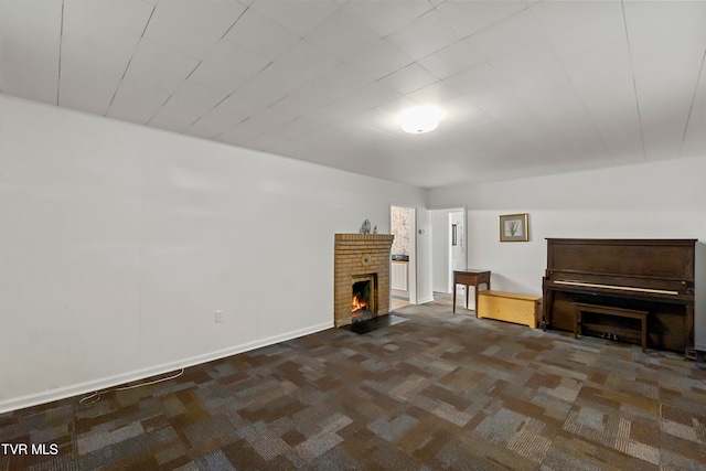 unfurnished living room featuring a fireplace and dark colored carpet