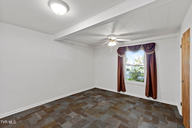 spare room with beamed ceiling, dark carpet, and ceiling fan