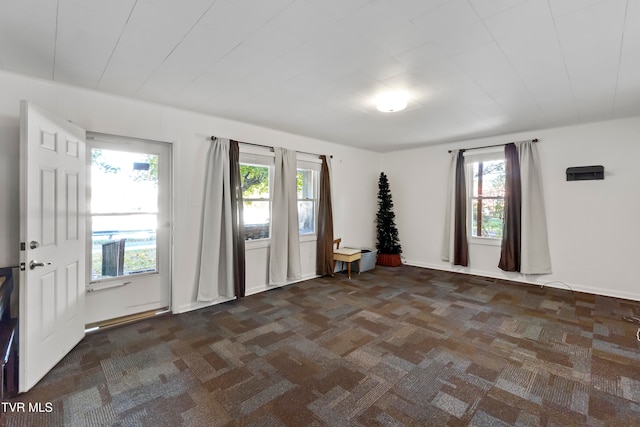 carpeted spare room featuring plenty of natural light