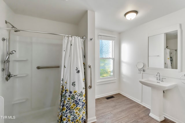 bathroom featuring hardwood / wood-style flooring and walk in shower