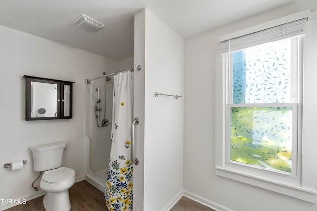 bathroom featuring hardwood / wood-style floors, curtained shower, and toilet