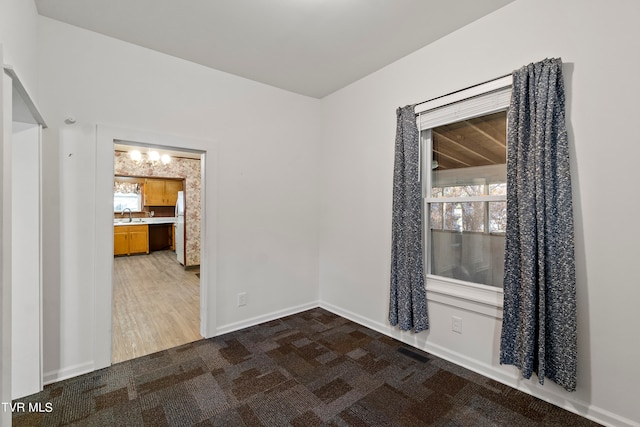 empty room featuring hardwood / wood-style floors, sink, and a healthy amount of sunlight