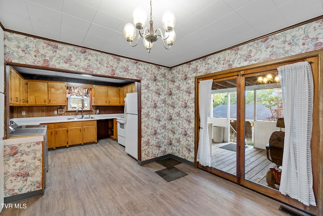 kitchen with pendant lighting, sink, light wood-type flooring, and white appliances