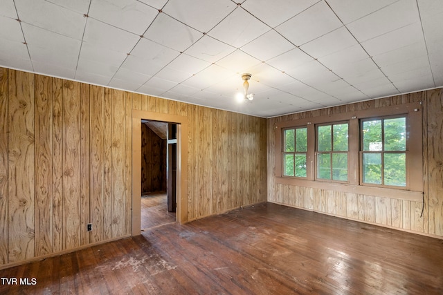 empty room featuring dark hardwood / wood-style flooring and wooden walls