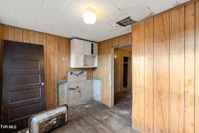 interior space with dark wood-type flooring and wood walls