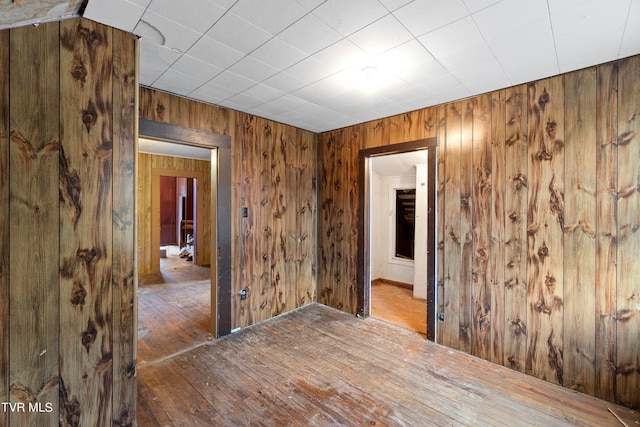 spare room featuring hardwood / wood-style flooring and wooden walls