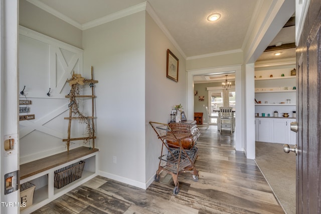 hallway featuring crown molding, hardwood / wood-style flooring, and a chandelier