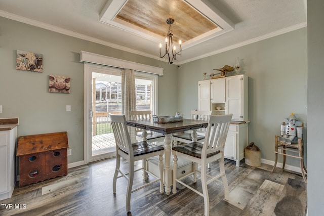 dining room featuring an inviting chandelier, crown molding, dark hardwood / wood-style floors, and a tray ceiling