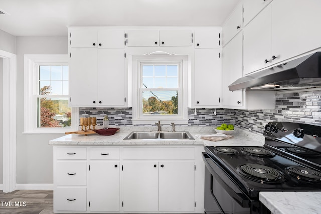 kitchen with sink, black / electric stove, white cabinetry, and tasteful backsplash