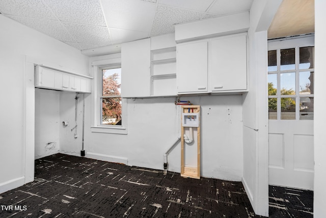 clothes washing area with cabinets