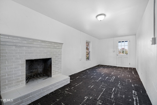 unfurnished living room featuring a brick fireplace