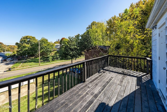 wooden deck featuring a lawn