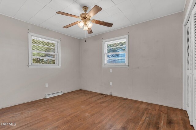 spare room with ceiling fan, hardwood / wood-style flooring, and a wealth of natural light