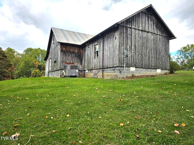 view of side of home with a lawn and an outbuilding